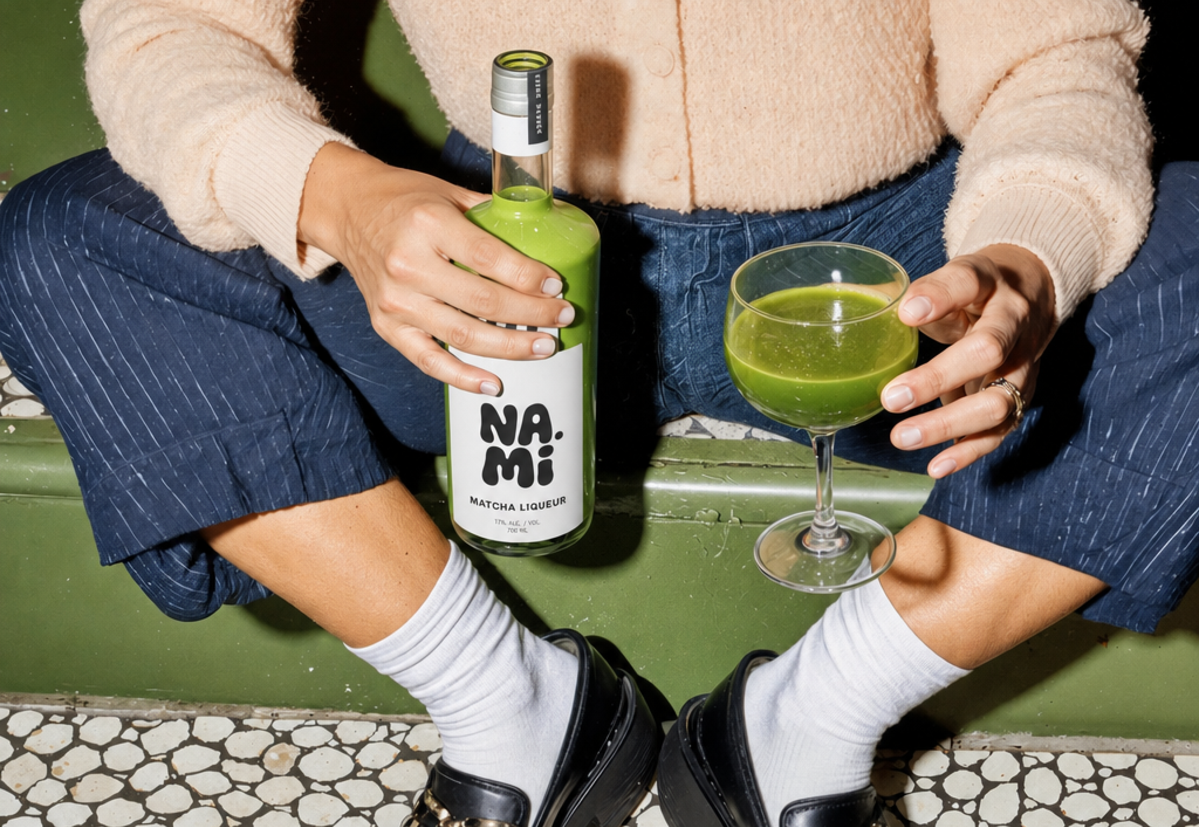 NAMI, friends holding the bottle and glasses over a green blanket