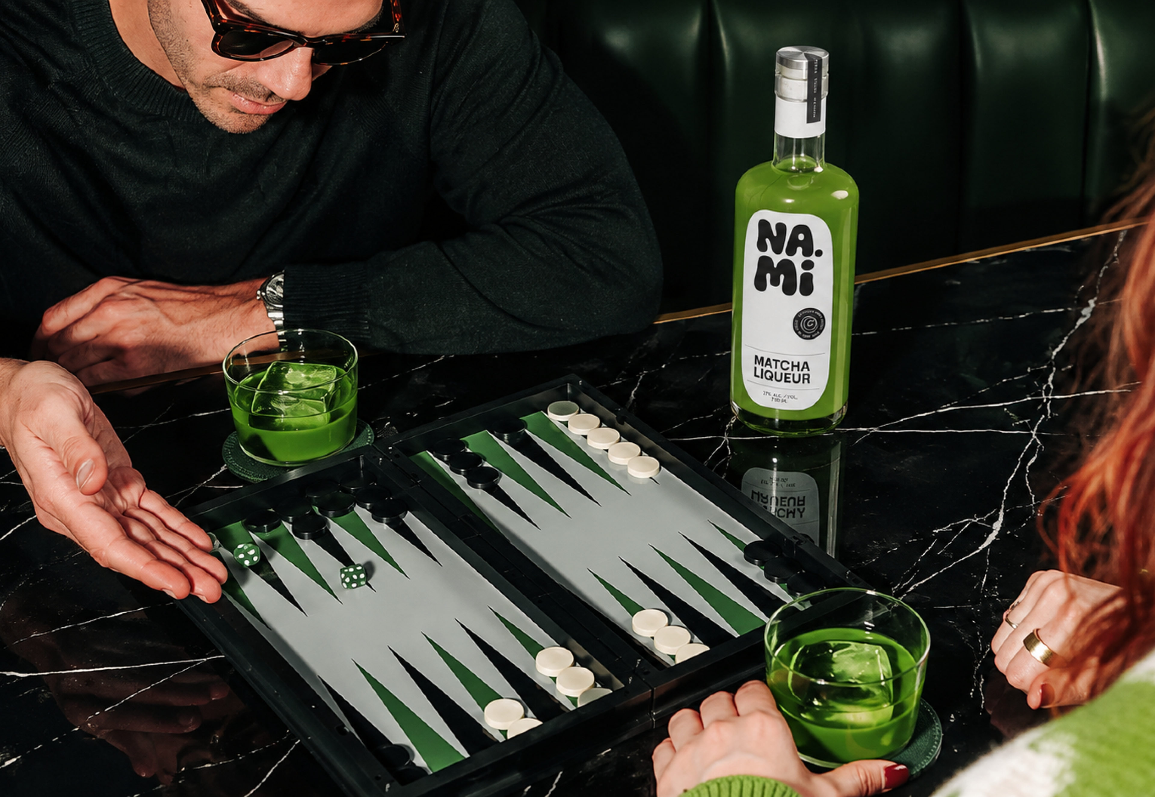 NAMI, friends reaching for drinks over a backgammon board