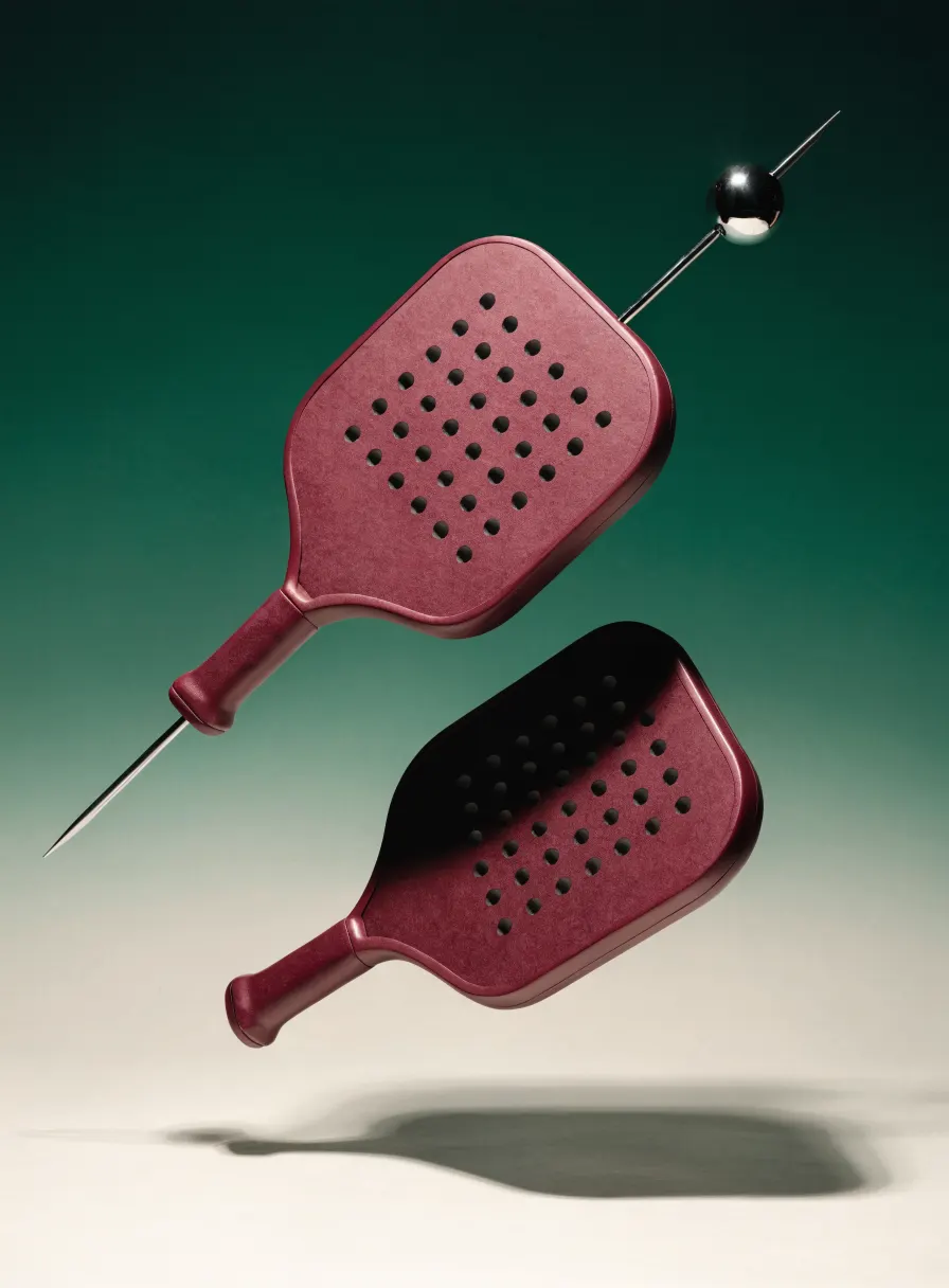 Picada, two burgundy padel rackets skewered like a cocktail pick